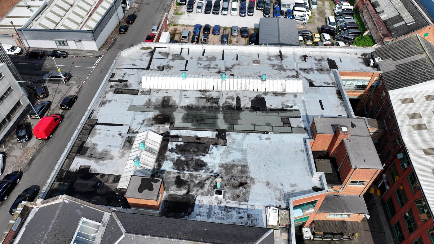 Drone aerial of an aged commercial roof assessed by Solar Surveys during a complete pre-installation roof condition survey for solar PV.