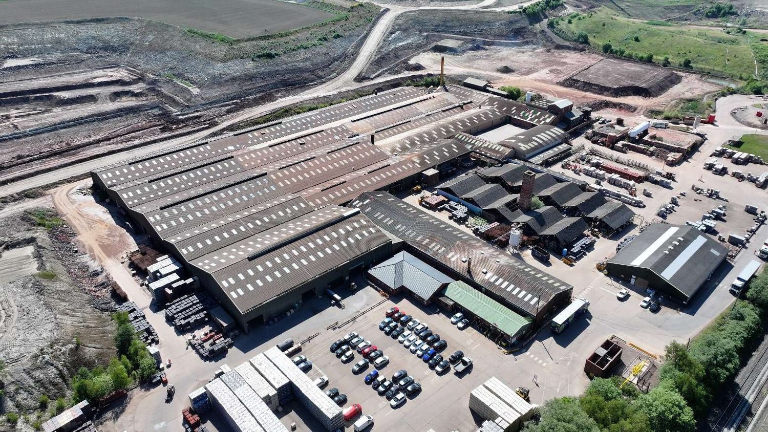 Aerial view of a large brick manufacturing works with extensive fragile fibre-cement roofs assessed by drone