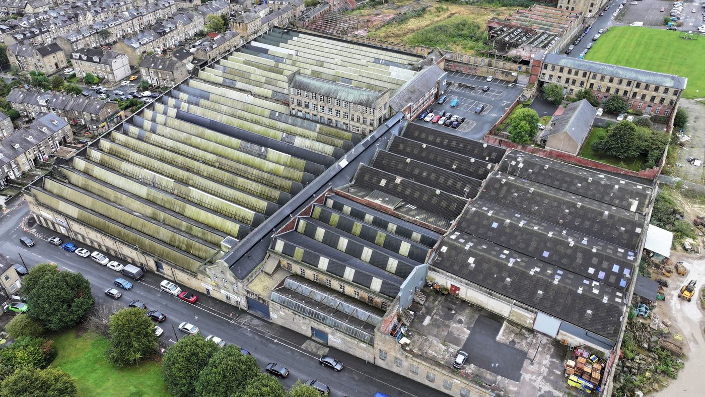 Aerial view of a large historic mill complex with twenty separate pitched roof bays assessed for rooftop solar PV