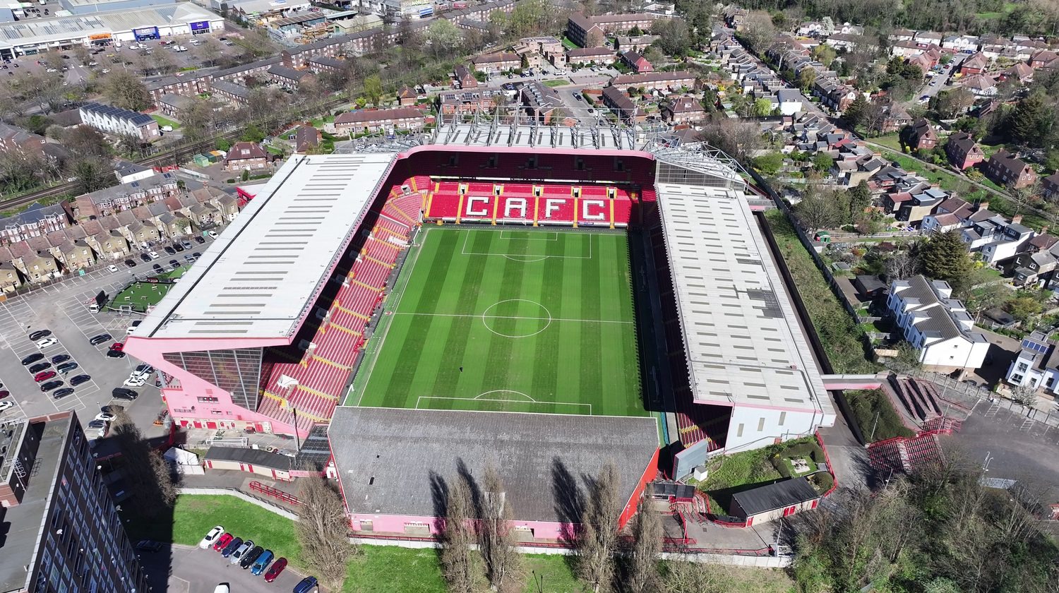 Aerial drone view of a football stadium with long-span monopitch stand roofs assessed for rooftop solar PV