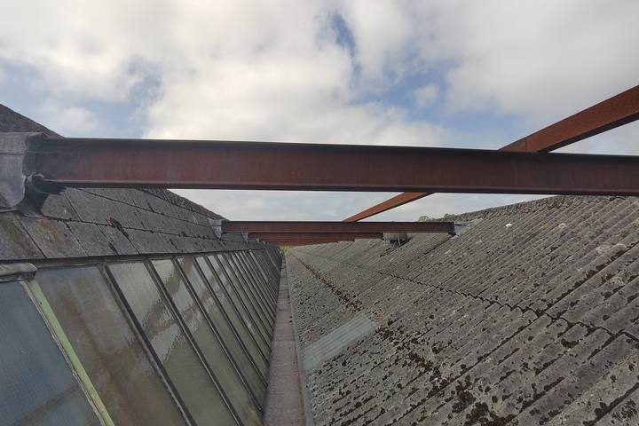 Corrugated fibre cement sheet roof with glazed rooflight bands
