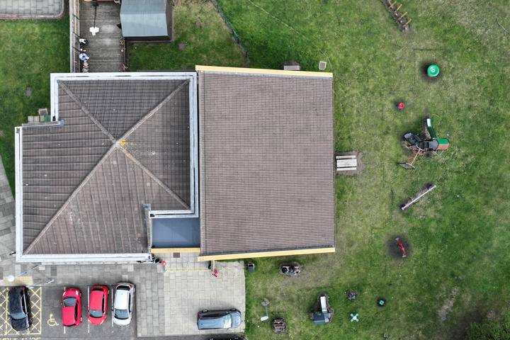 Overhead drone view of a community hall with hipped and gabled roofs