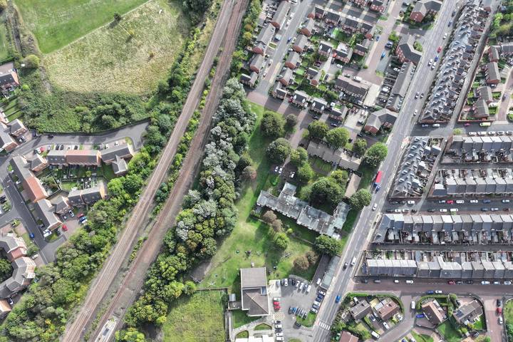 Drone view over terraced and semi-detached housing beside a railway line