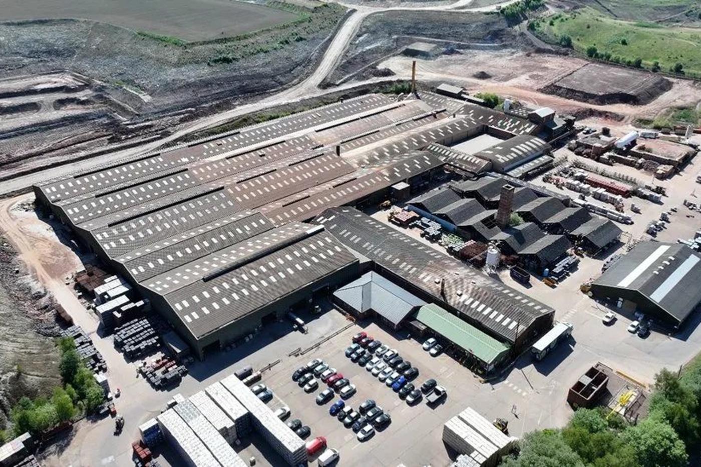 Aerial view of a heavy industrial works with long multi-bay sheet roofs