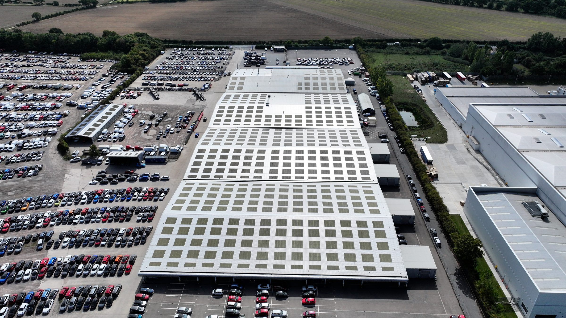 High-resolution drone aerial of large commercial flat roof showing full skylight grid and visible drainage and surface condition data captured for roof condition assessment ahead of solar PV installation